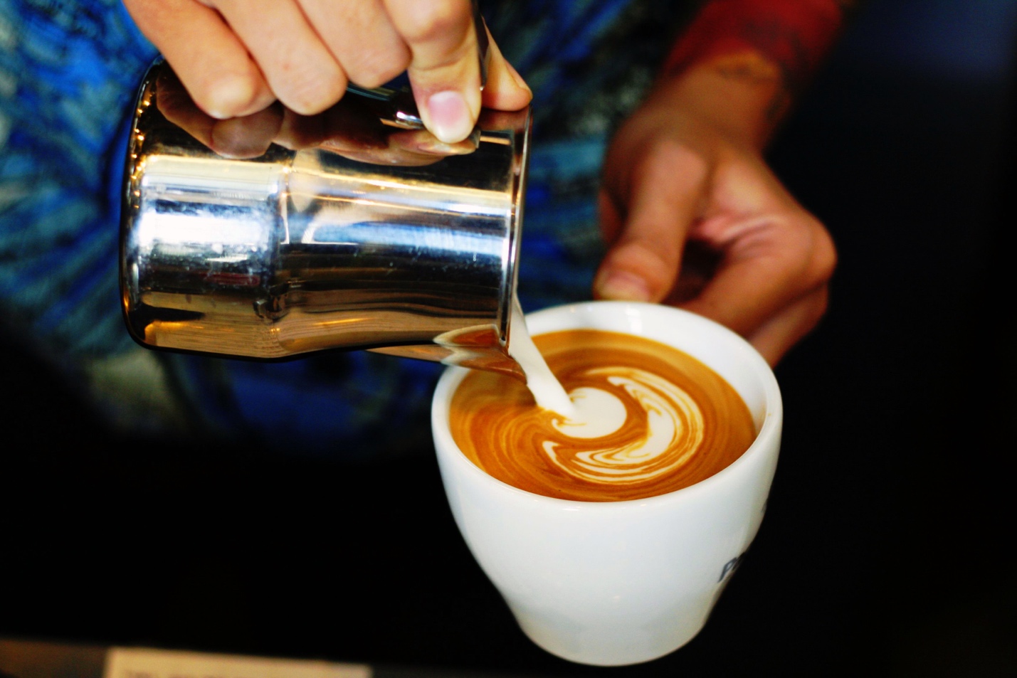 cream being poured in to coffee